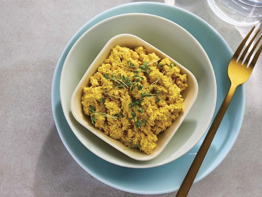 A plate of cauliflower scramble garnished with fresh herbs, served as a healthy plant-based alternative to egg-based breakfast.